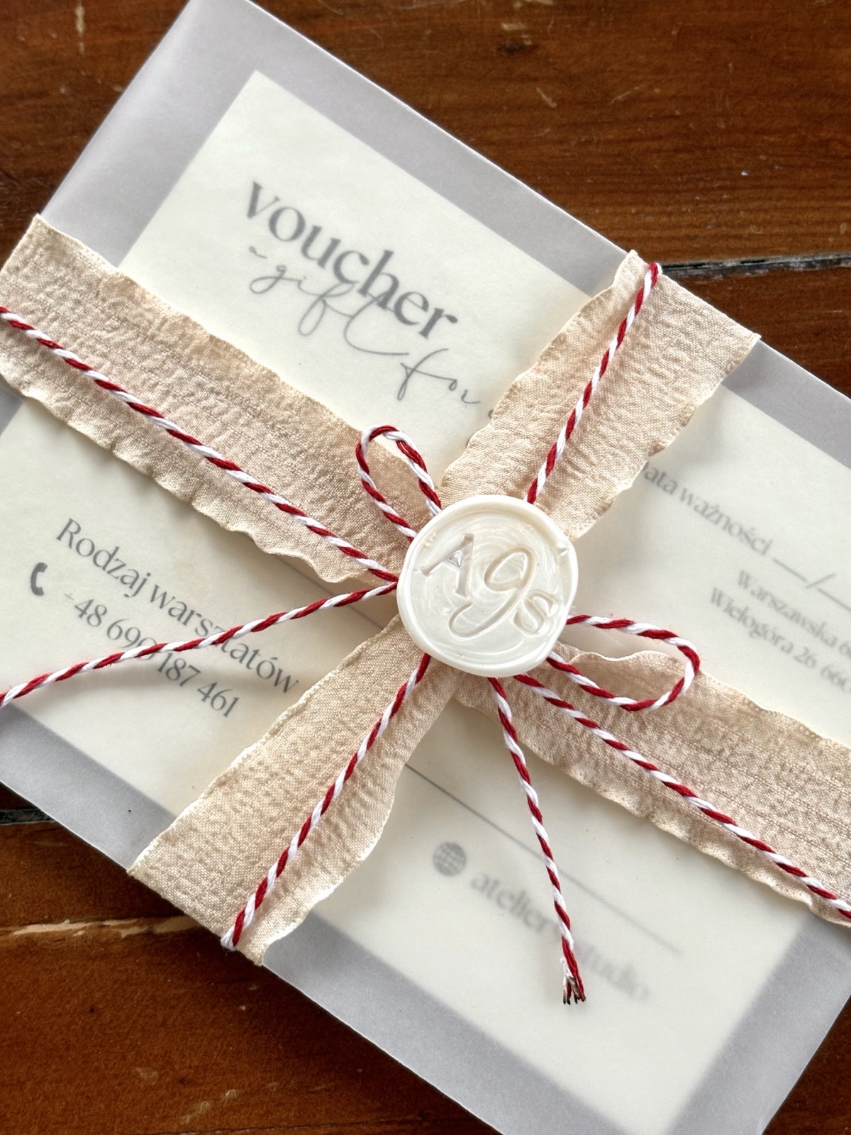 Voucher prezentowy Atelier9Studio — pakowany w lnianą wstążkę z pieczęcią woskową A9S